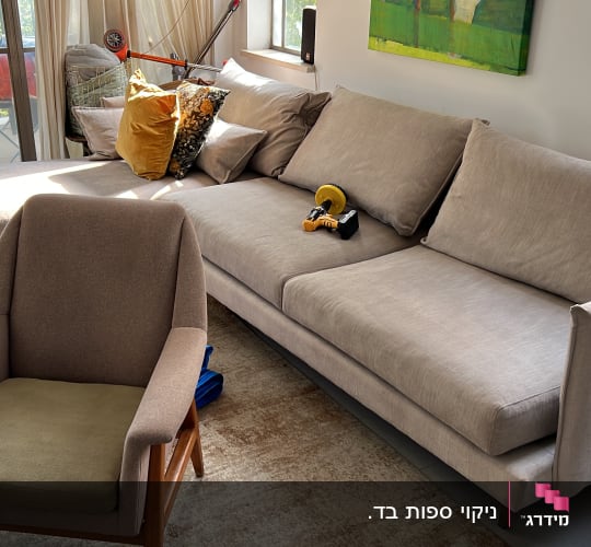 ספה עם כלי ניקוי מונח עליה בחדר מואר